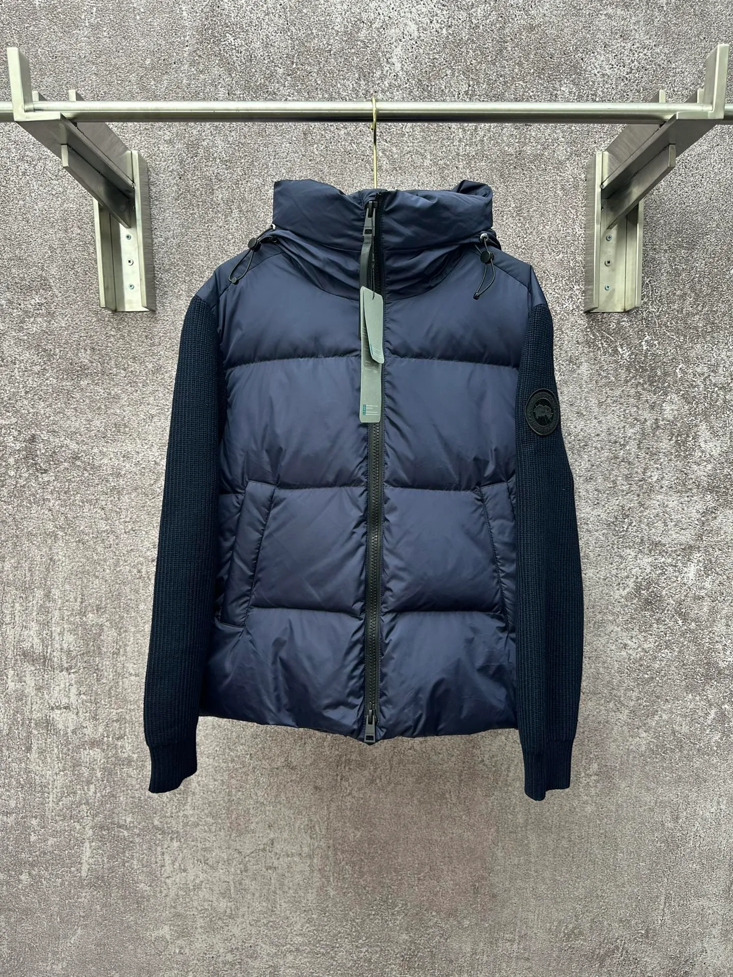P930 Canada Goose Armband Hooded Down Jacket Fabric selection: The use of high-quality protective nylon fabric not only enhances the wear resistance of the surface, but also takes into account wind resistance, ensuring excellent performance in various harsh weather conditions.  90 national standard high-quality white duck down: selected high-loft down, weighing 170g, light and warm, with excellent temperature locking performance and good resilience.  Three-dimensional quilting process: Precision thread reinforcement to prevent velvet drilling and ensure that the fluffy and resilient elasticity lasts as new.  7-needle medium-thick knitted structure: Use thicker yarns to knit woolen fabrics with obvious thickness and weight. The texture is clearly visible and has a rough, retro texture. It has a good skeleton feel, is relatively stiff, and can maintain the silhouette of clothing for a long time. It also provides more layers of still air to lock in heat.  There is a brand exclusive LOGO on the woolen sleeve arms. It is dark and not obvious in the photo.  Accessories: One-to-one customized logo, one-to-one customized zipper pendant, one-to-one customized snap button SIZE: S M L XL